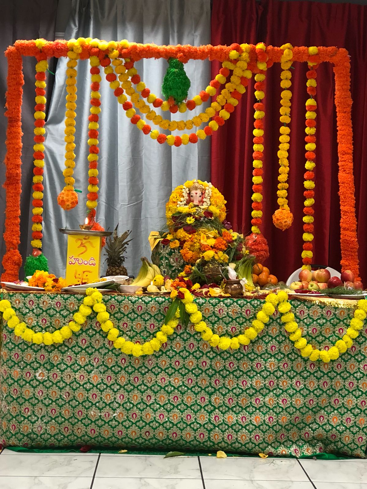 Ganesh altar decorated with orange and yellow marigold garlands, 2018