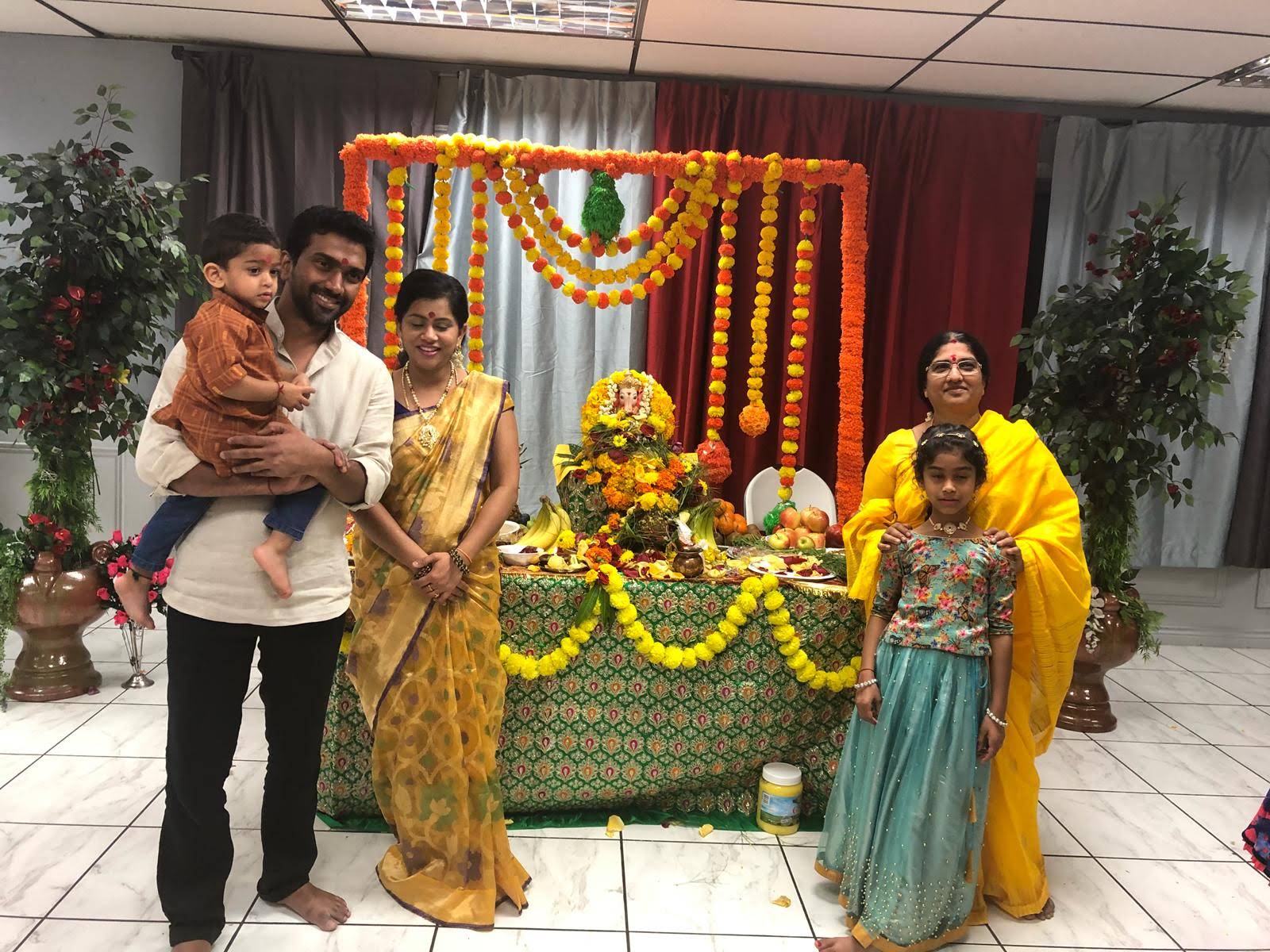 Family posing before the decorated Ganesh mandap, 2018